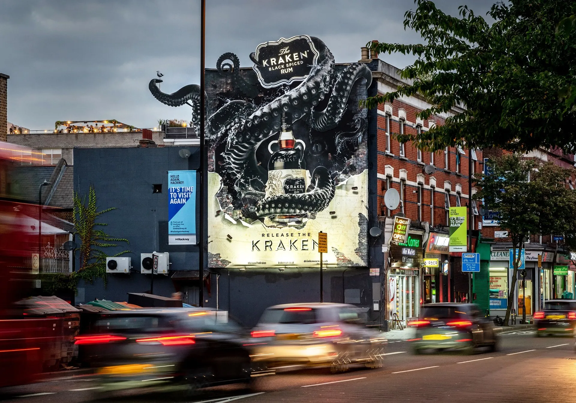 a man walking down a street past a large poster