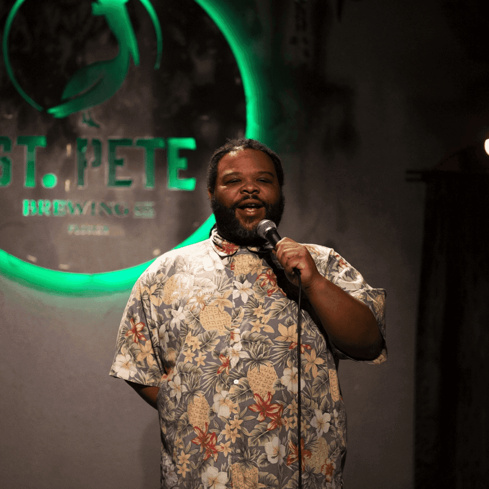 A hilarious male comedian performing on stage at a St Pete Standup show