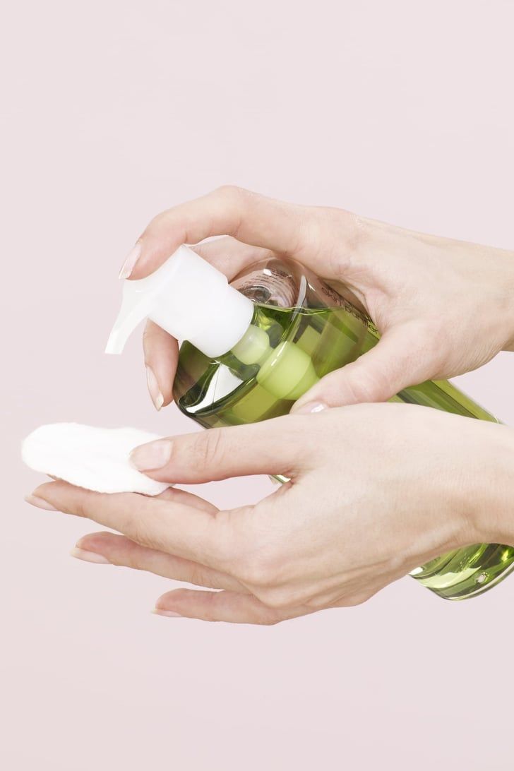 Hands pumping green toner from a bottle onto an open palm