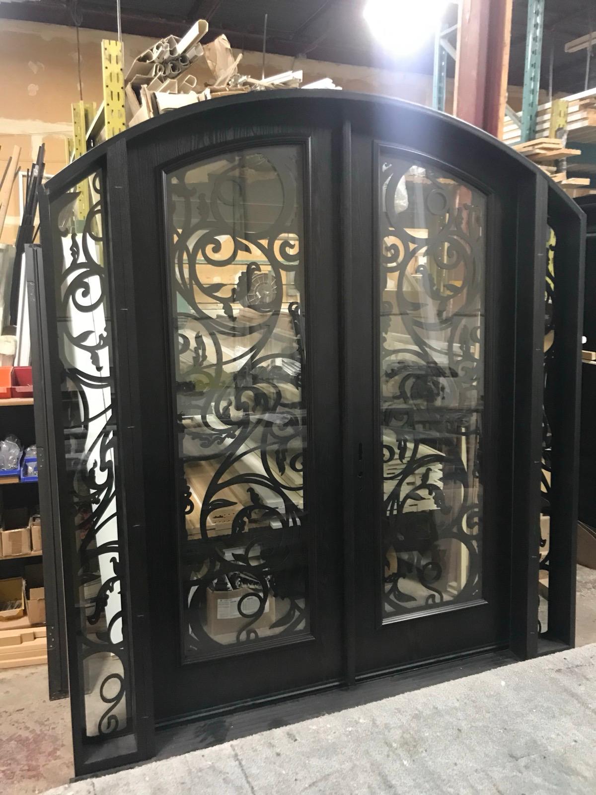 Arched wrought iron double entry door with scrollwork glass being assembled in the Door Gallery workshop in Concord, Ontario