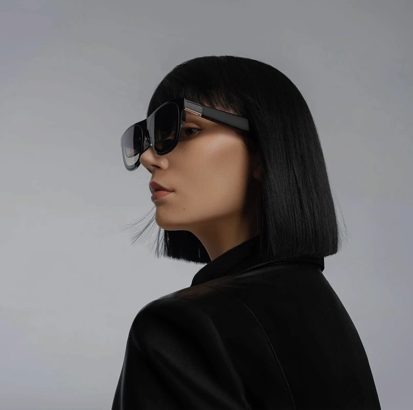 Model wearing XREAL AR glasses in a side profile portrait against a neutral background