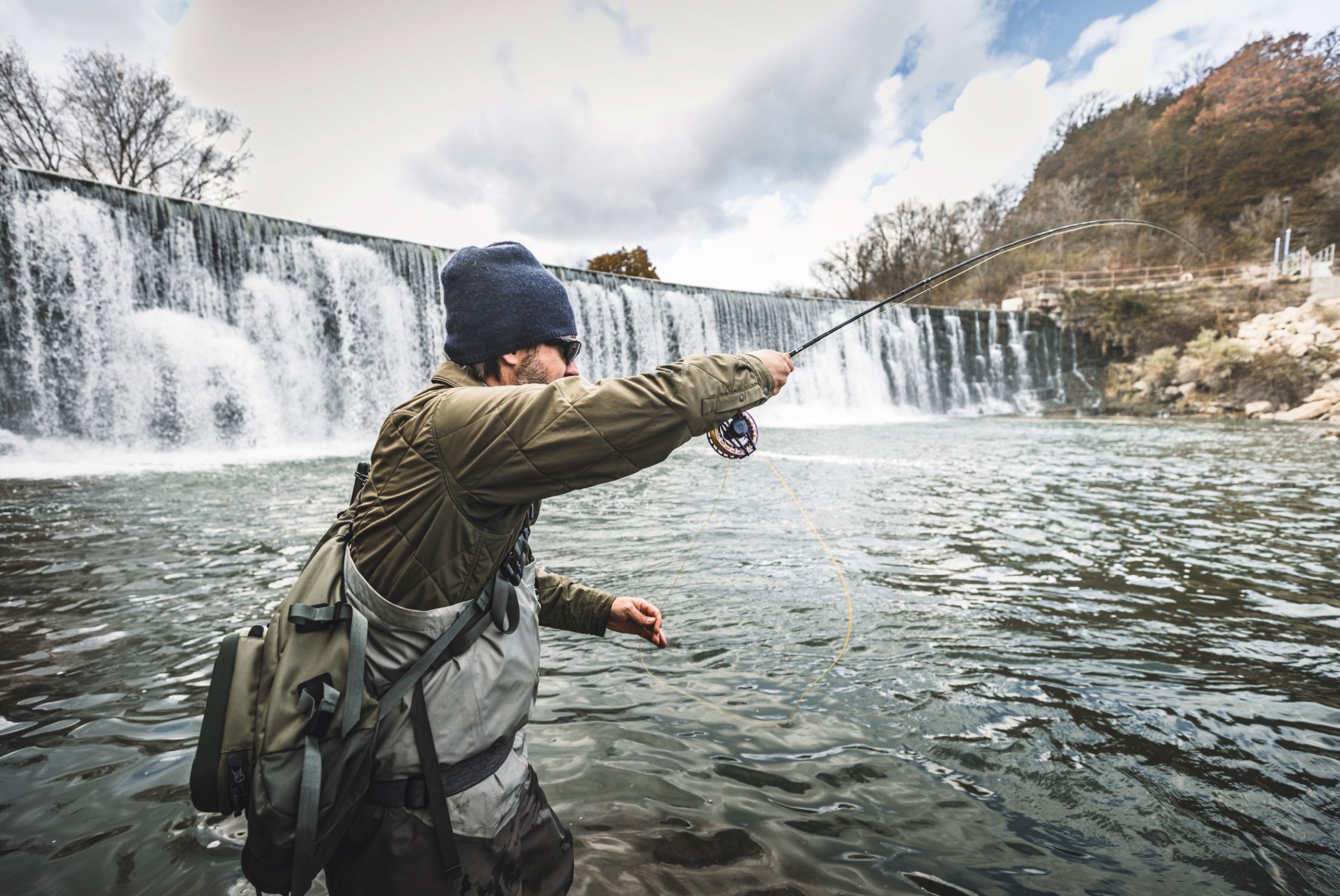 man casting a fly fishing rod in snowy water waterfall taylor fly rod