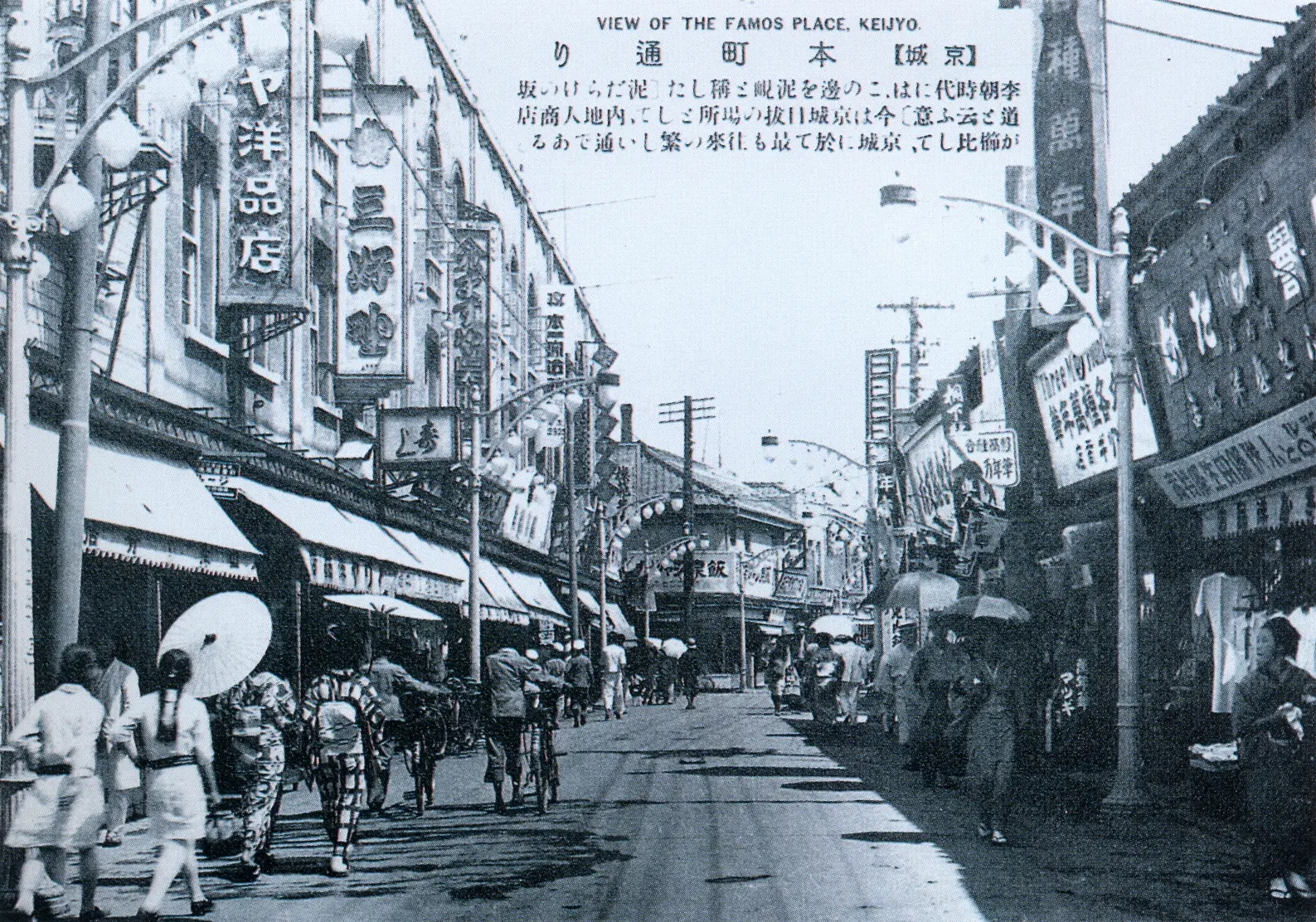 Zdjęcie przedstawiające Myeongdong w Seulu w okresie japońskiej kolonizacji (ok. lat 30. XX wieku); wszystkie szyldy są po japońsku, a ulicą spacerują kobiety w kimonach. Napis u góry zdjęcia brzmi: „widok na słynne miejsce, keijyo” [pisownia oryginalna]