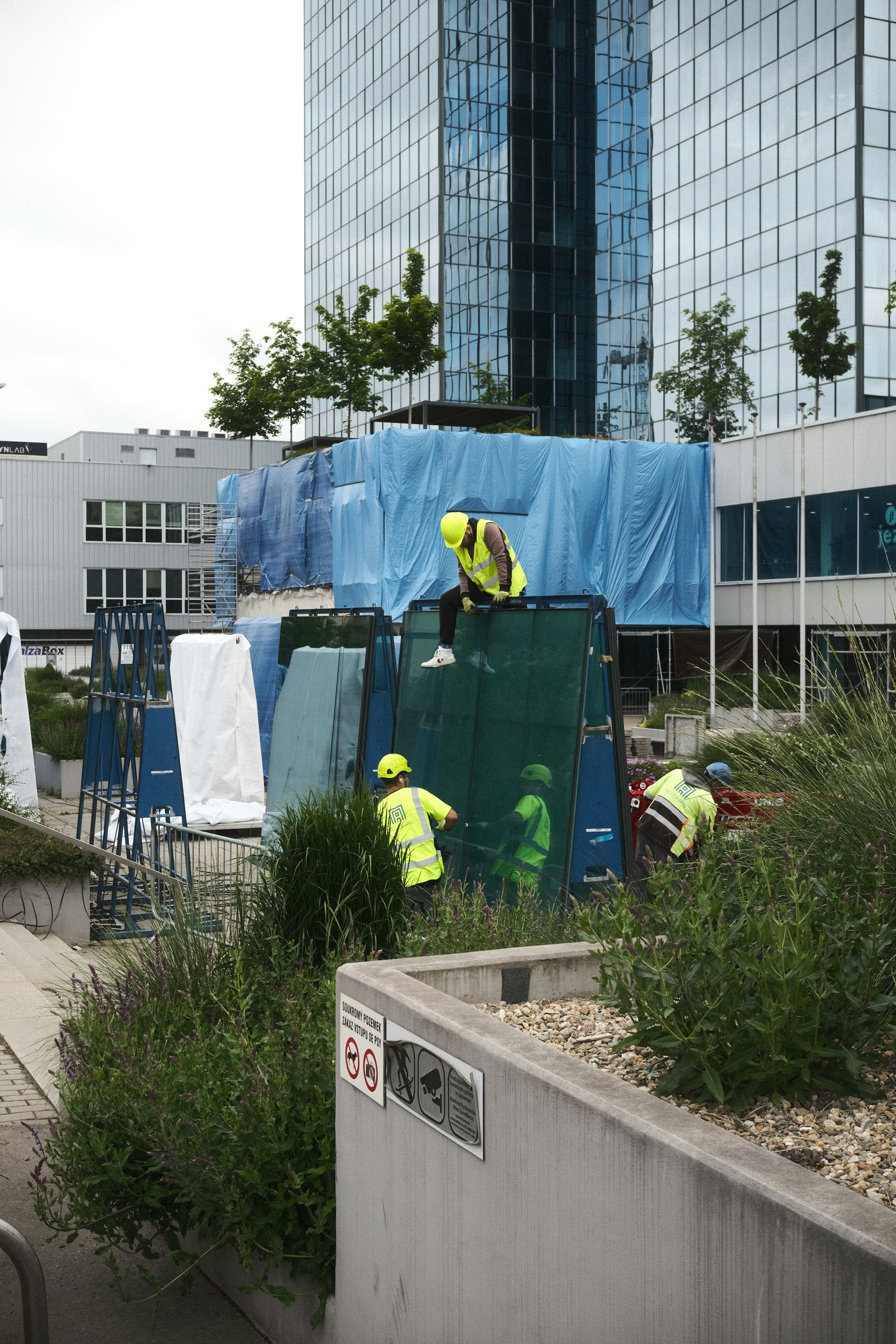 Construction workers work near a high-rise building.