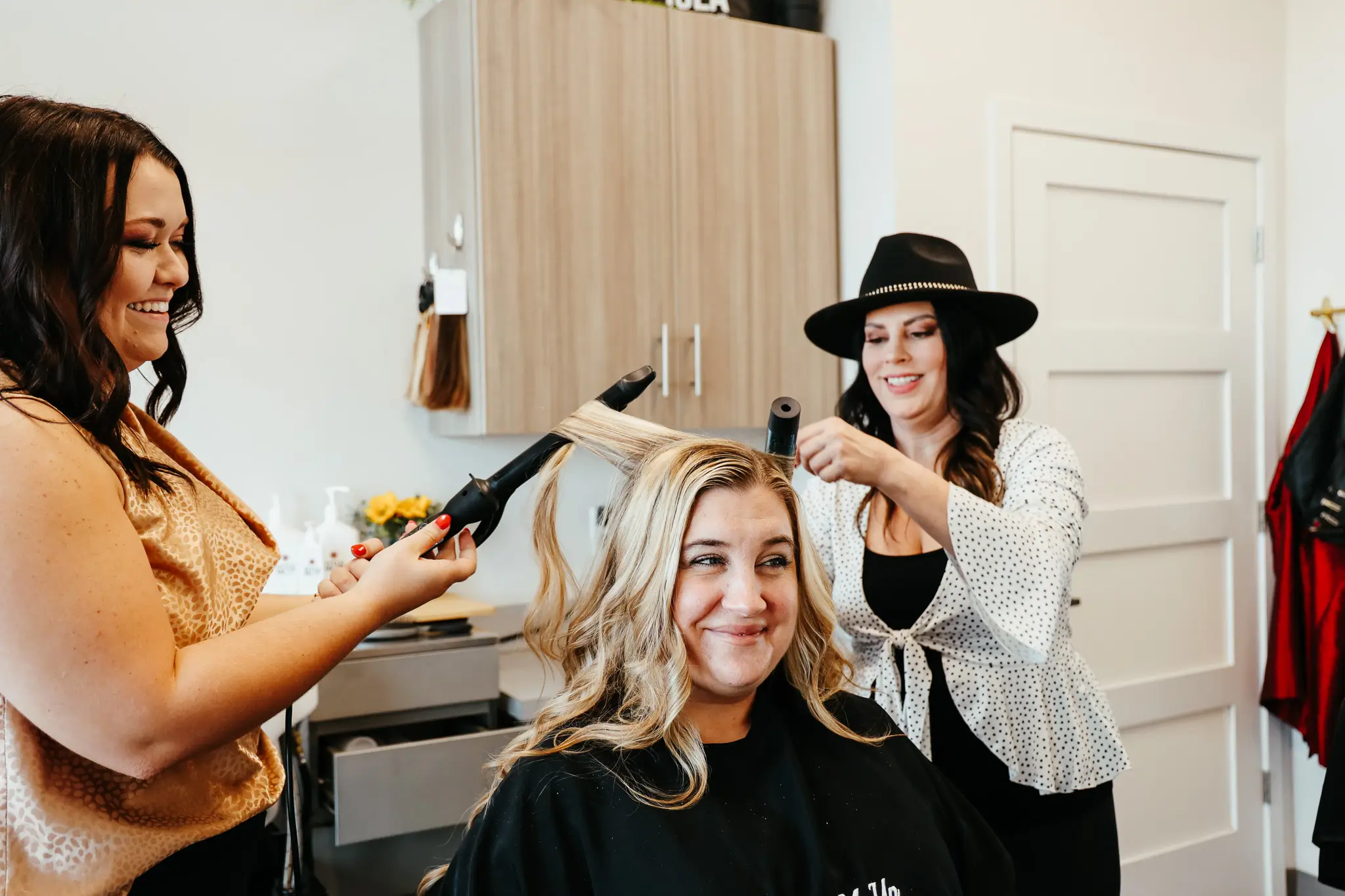 Photo of Style Me Up team members styling a woman's hair.