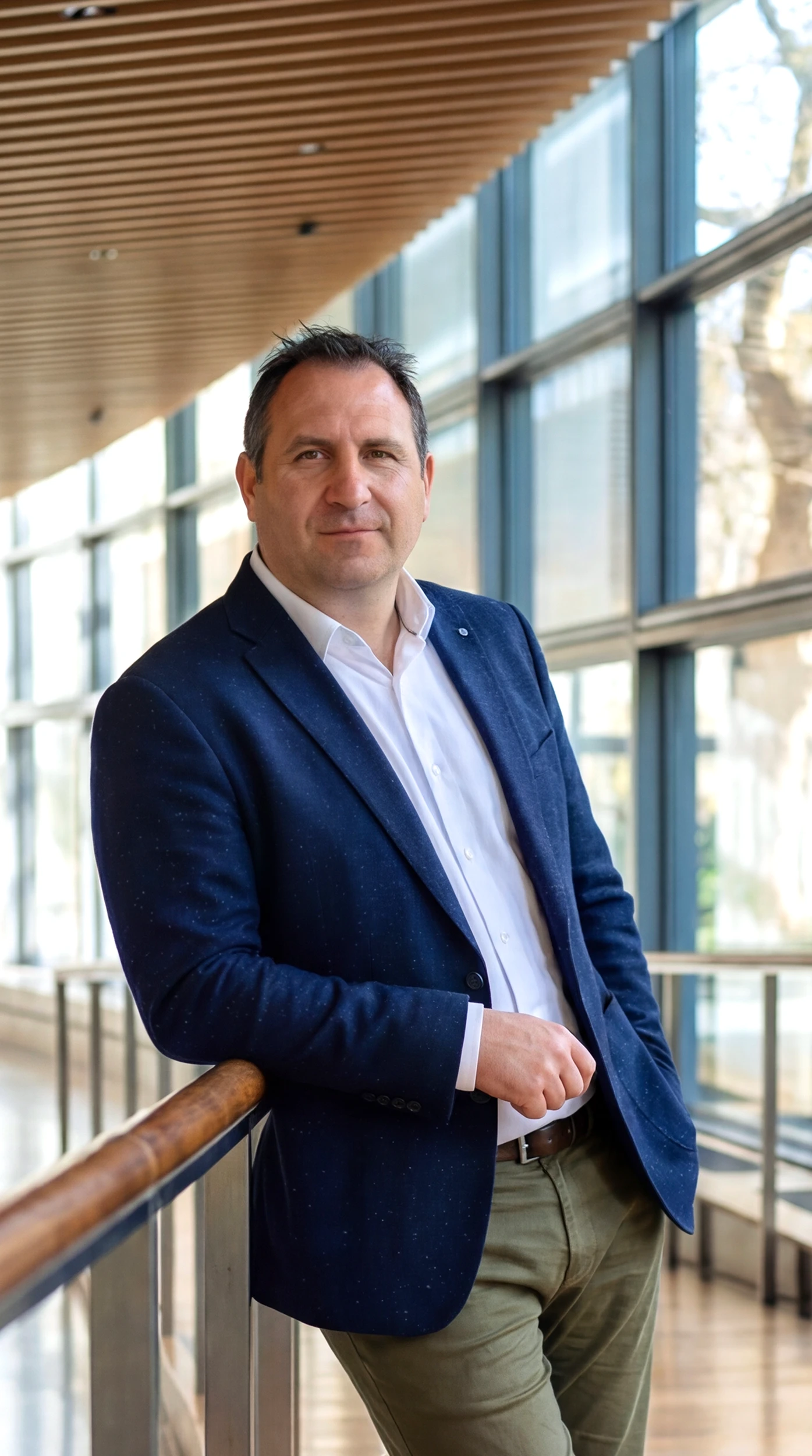 Portrait of a laughing person with curly hair wearing a white shirt