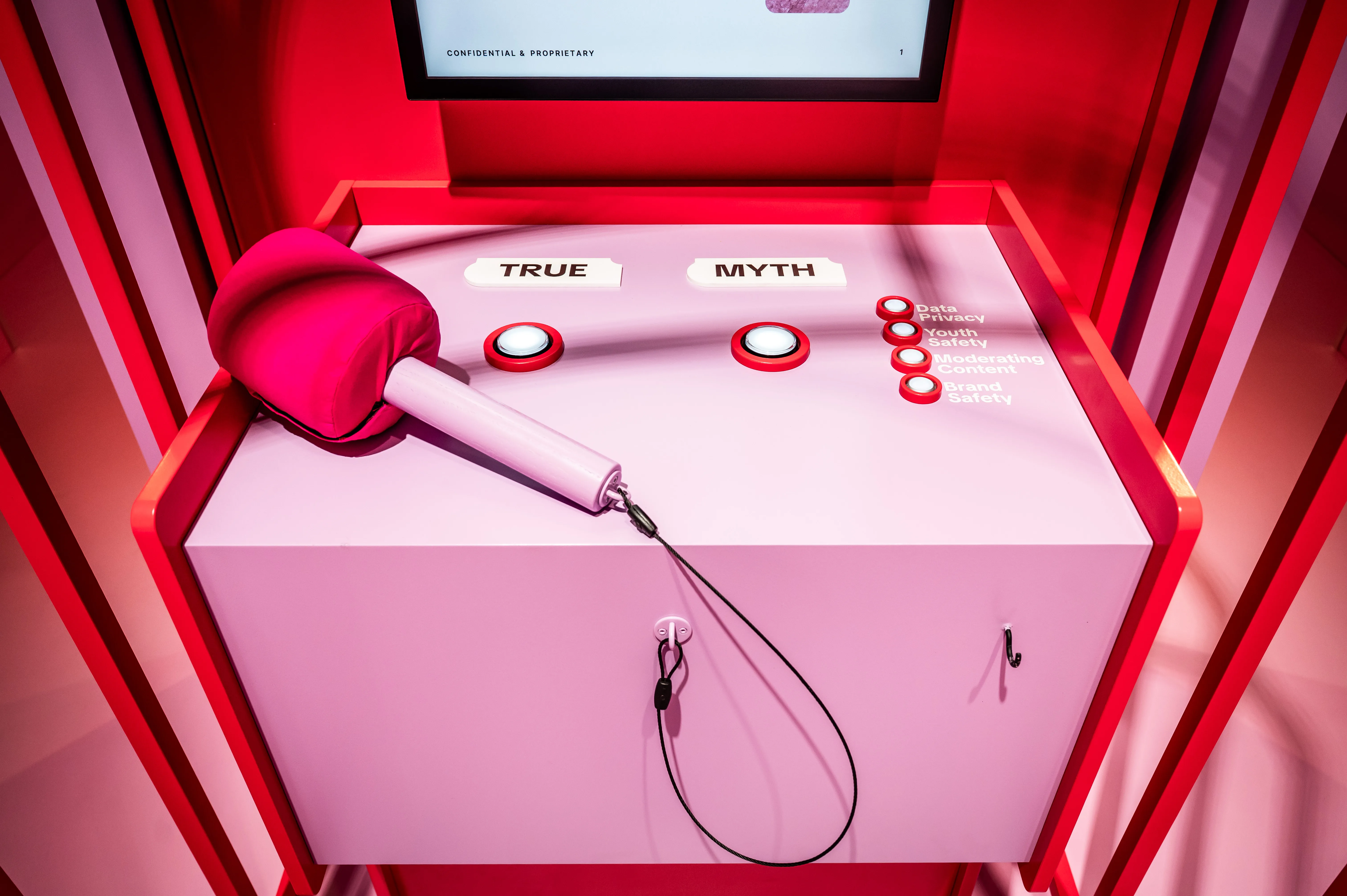 Pink game console with plush hammer and True or Myth buttons at the TikTok Whack-A-Myth station.