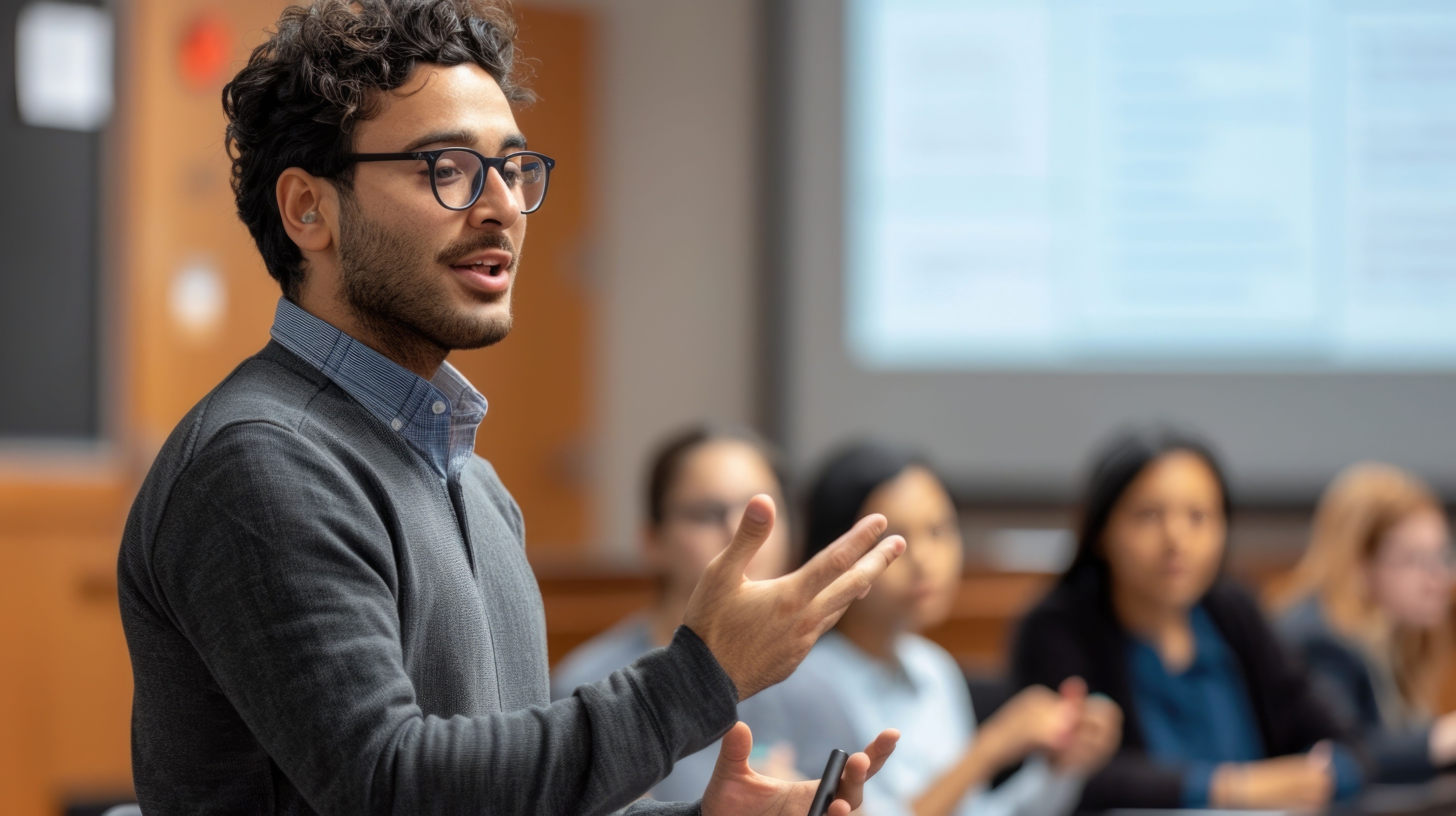 Trainer presenting to professionals during a management systems training session, with participants listening in a classroom setting.