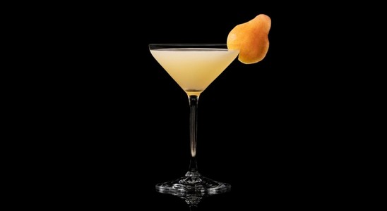 A closeup of a Pear Martini drink against a dark background.