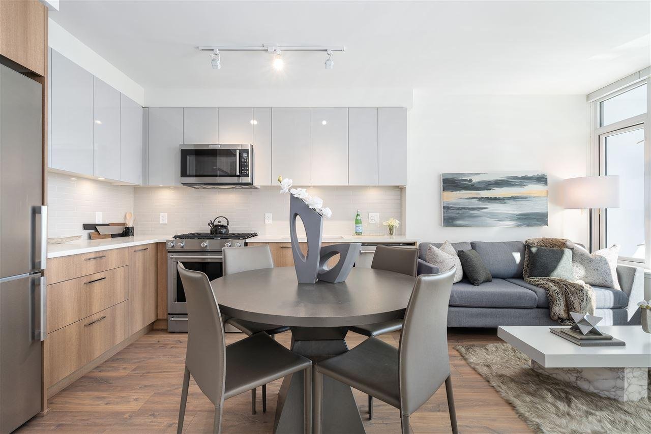 Modern kitchen and dining area featuring a round table, sleek appliances, and contemporary decor.