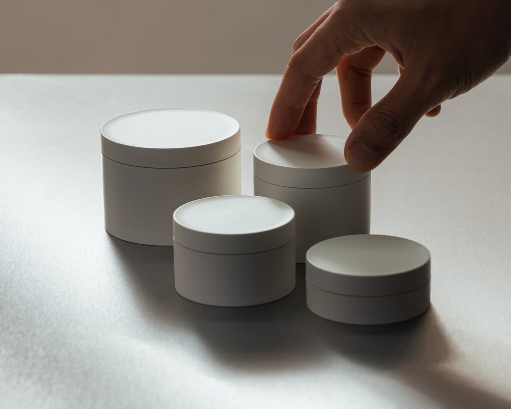 A collection of premium VIVOMER cosmetic tubs and jars in various catalogue sizes. These thick-walled, retail-ready containers provide the luxurious tactile feel and moisture barrier of conventional plastic packaging for creams and balms, but are entirely petroleum-free and home-compostable.