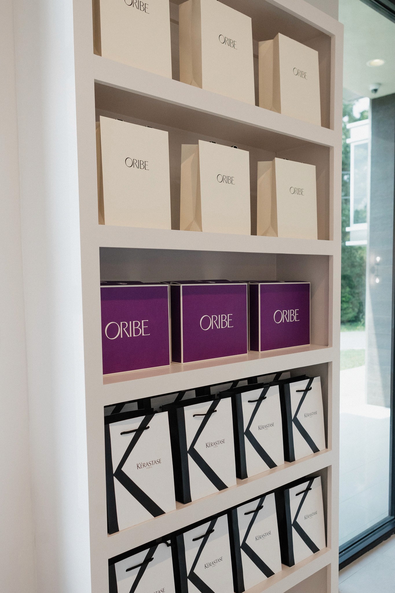 Smiling young man with short hair poses against a dark background, wearing a green button-up shirt.