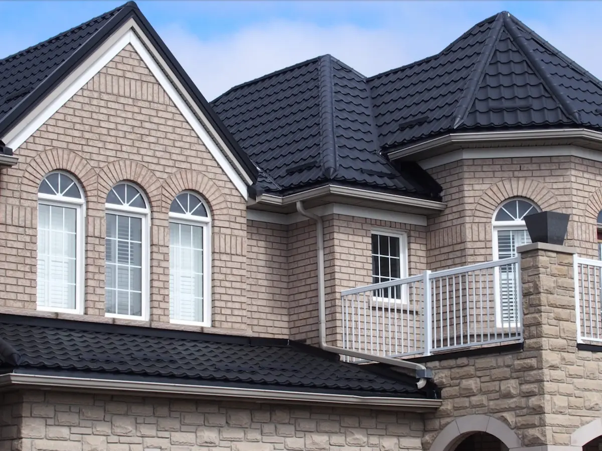 Toiture métallique gris anthracite sur maison avec balcon en fer forgé au Québec