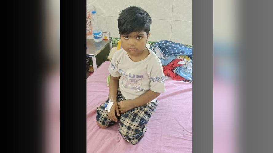 A couple of kids that are sitting in the grass