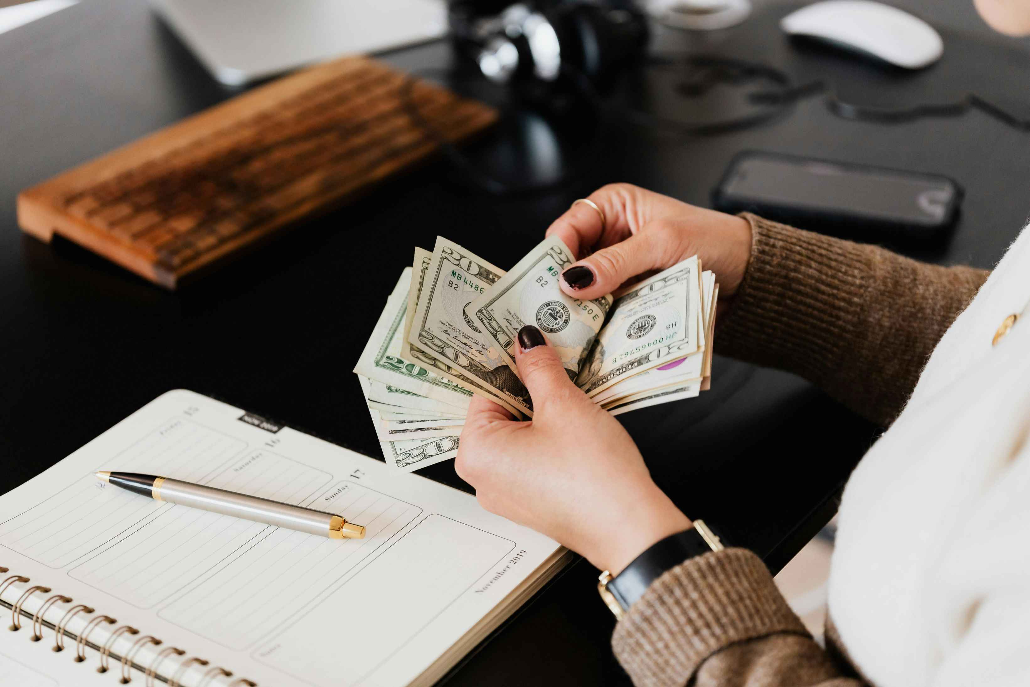 woman counting cash and taking notes