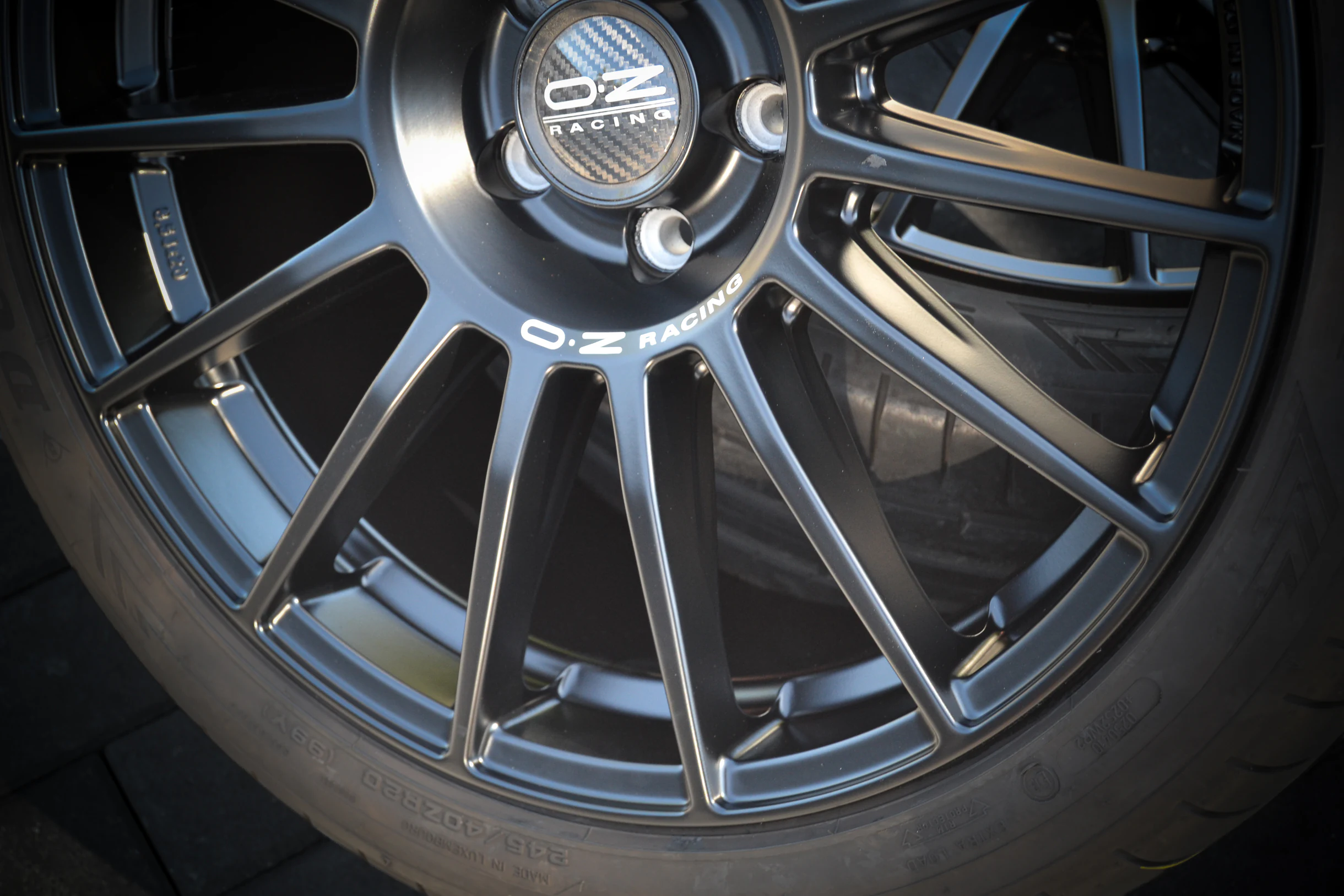 Detail der Nabenpartie und schmalen Speichen einer dunklen OZ-Racing-Felge bei AT Plus.