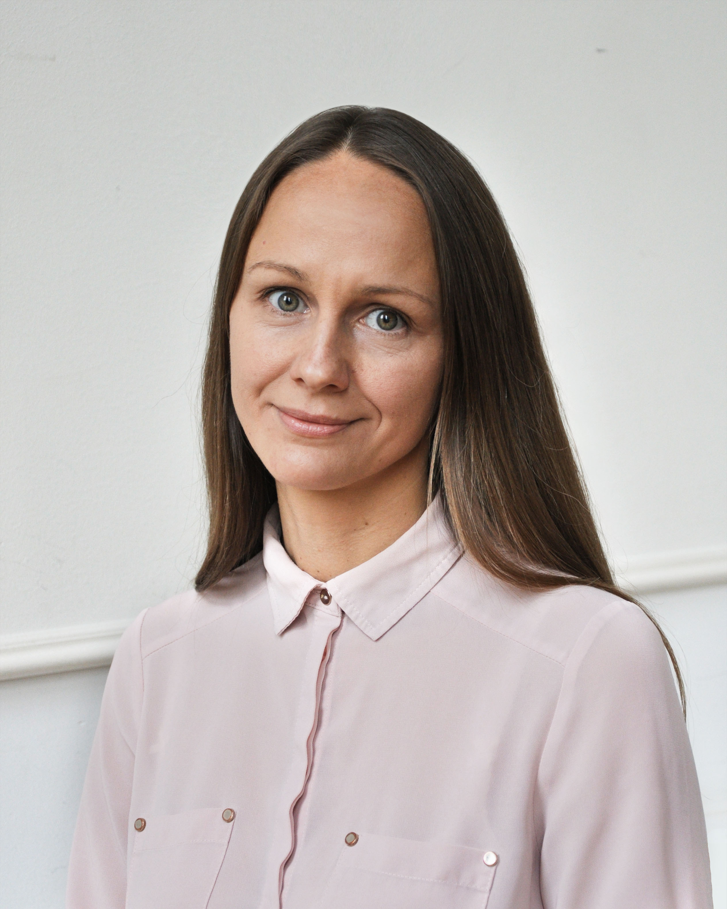 Portrait of Yuliia, the helpline lead at Empatia by OPORA, wearing a white shirt and looking confidently at the camera.