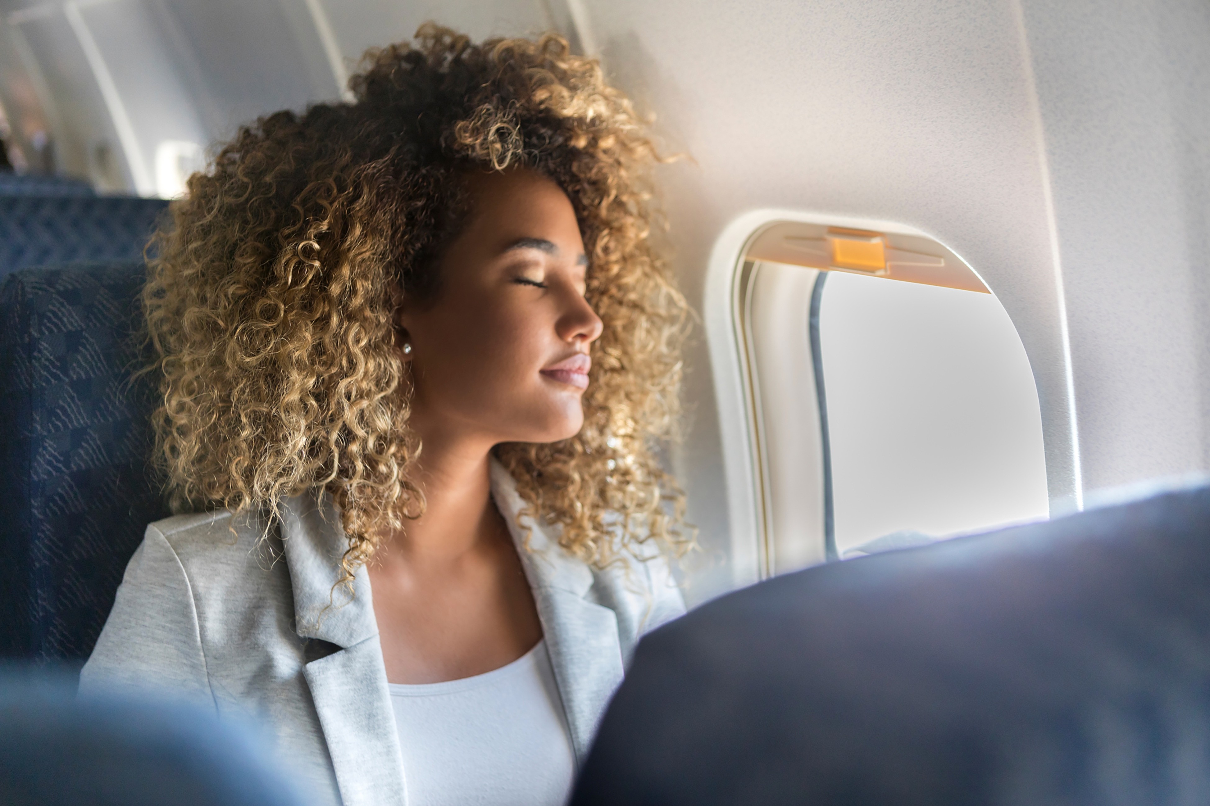 Mujer con expresión relajada disfrutando del sonido durante un viaje, como resultado de su rehabilitación auditiva