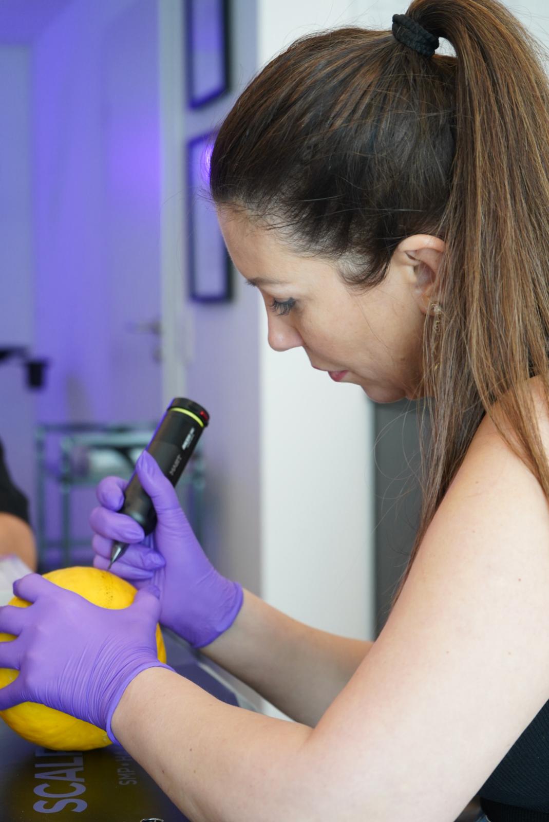 Teilnehmerin übt SMP Technik mit Pigmentiergerät an Trainingsmodell – Technik & Perfektion am zweiten Ausbildungstag der Scalp Couple SMP Akademie