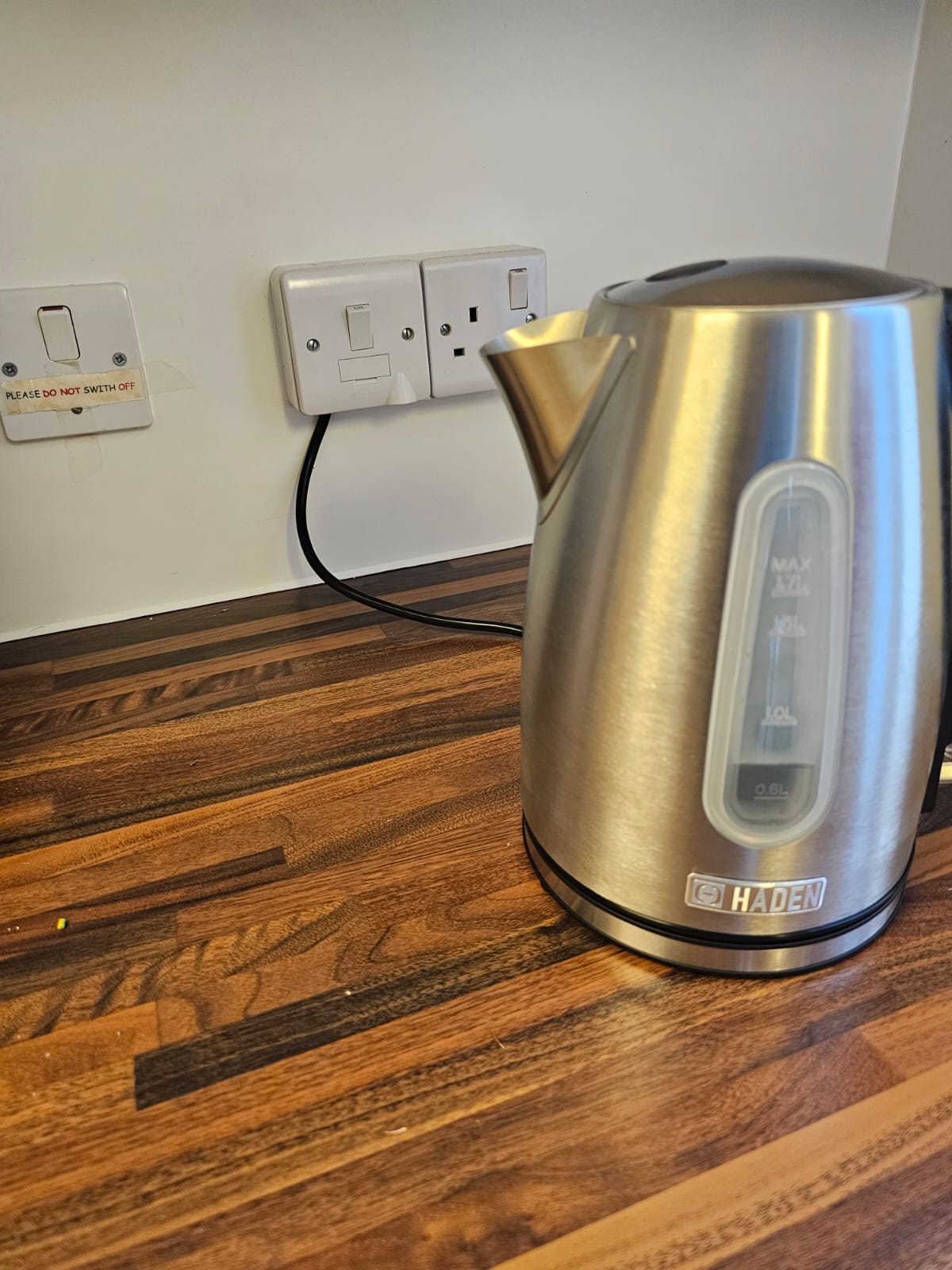 Commercial electrical installation image, showing water kettle plugged straight into the wall with no socket