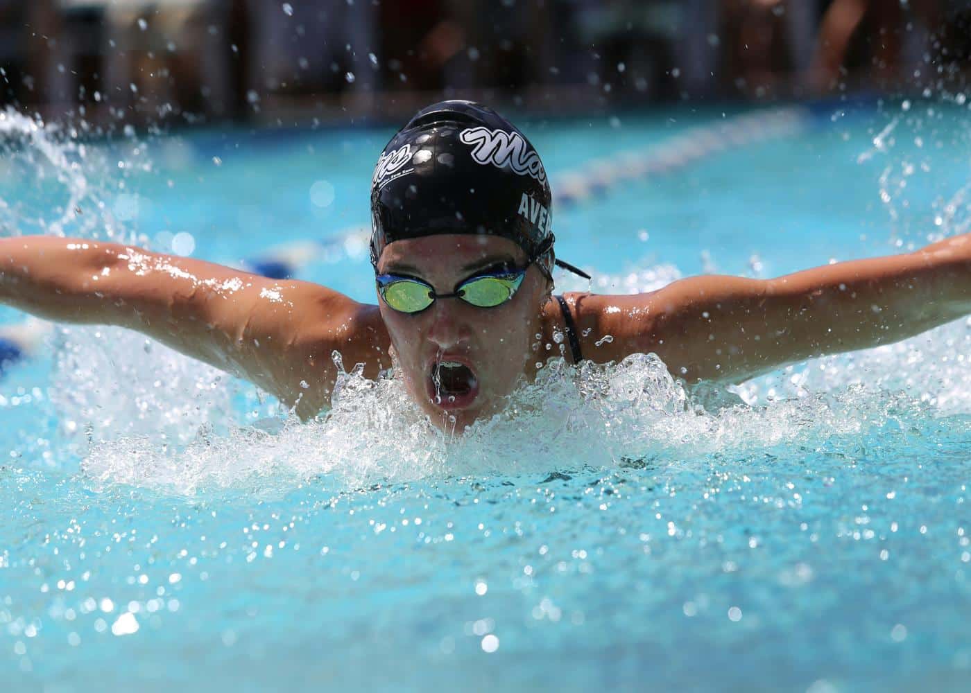 Man swimming while wearing swimming goggle earphones