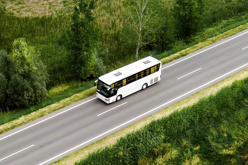 A commercial bus seen from above driving along a roadway, accompanying the bus accident case information