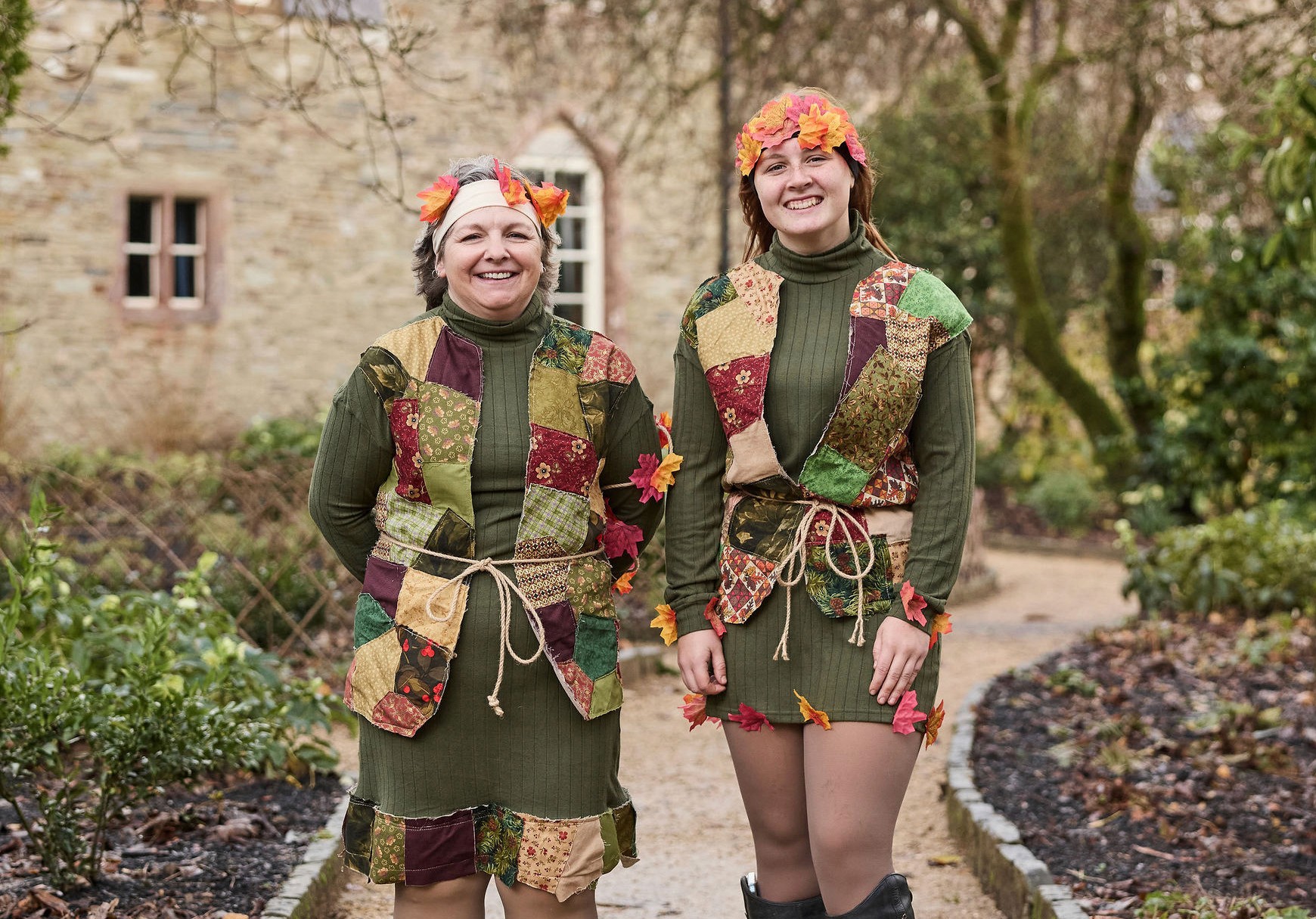 Two piskies dressed in their woodland finery stand outside the rectory.