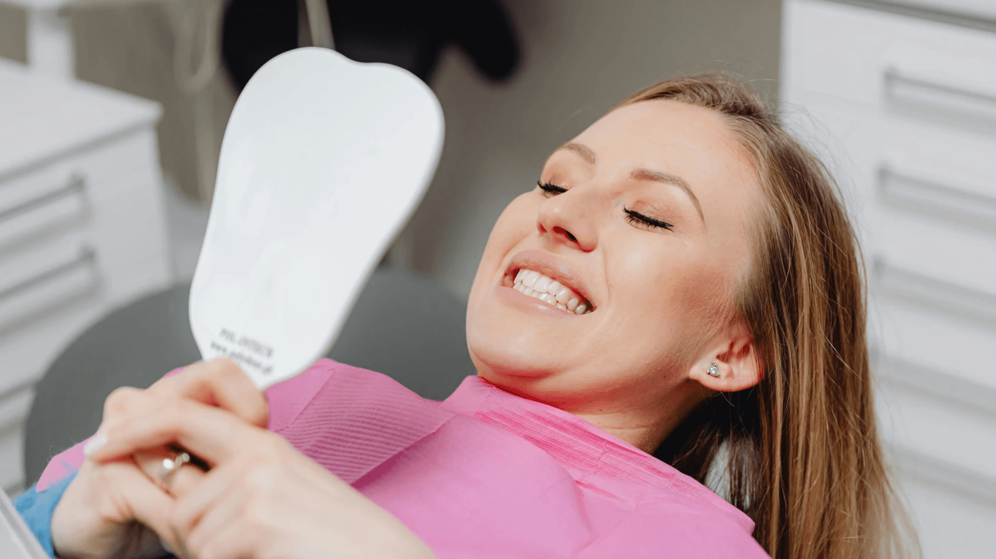Woman smiling at her teeth after orthodontic treatment for gap teeth. 