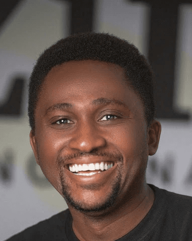 a man with a goatee smiles at the camera