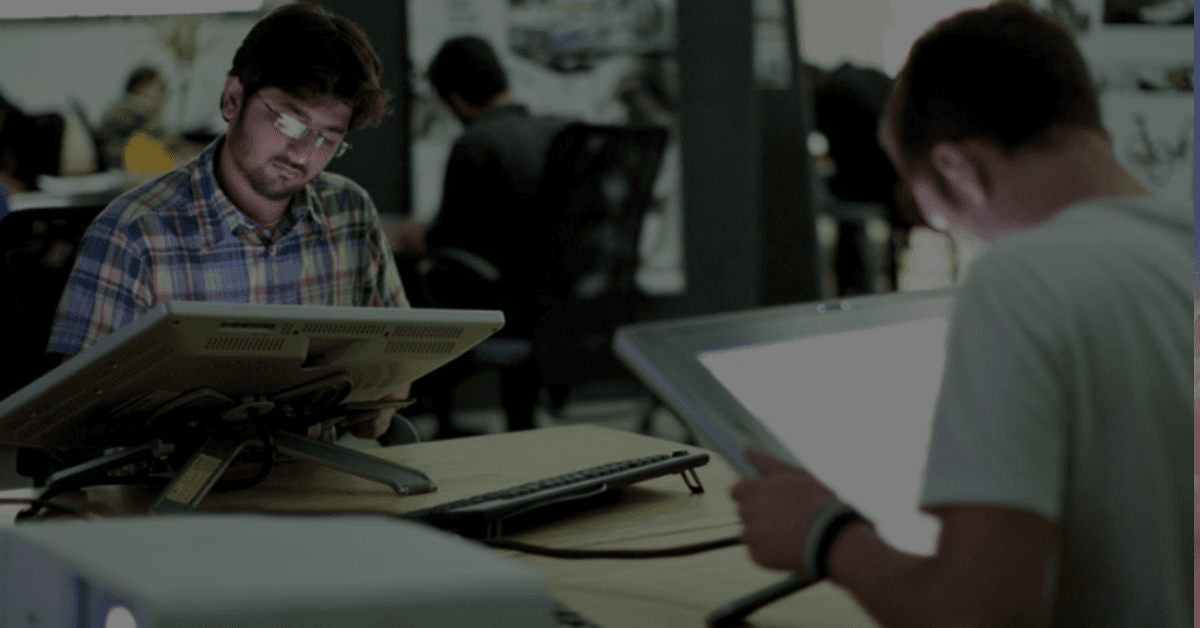 Deux designers travaillent sur des tablettes graphiques dans un bureau moderne.