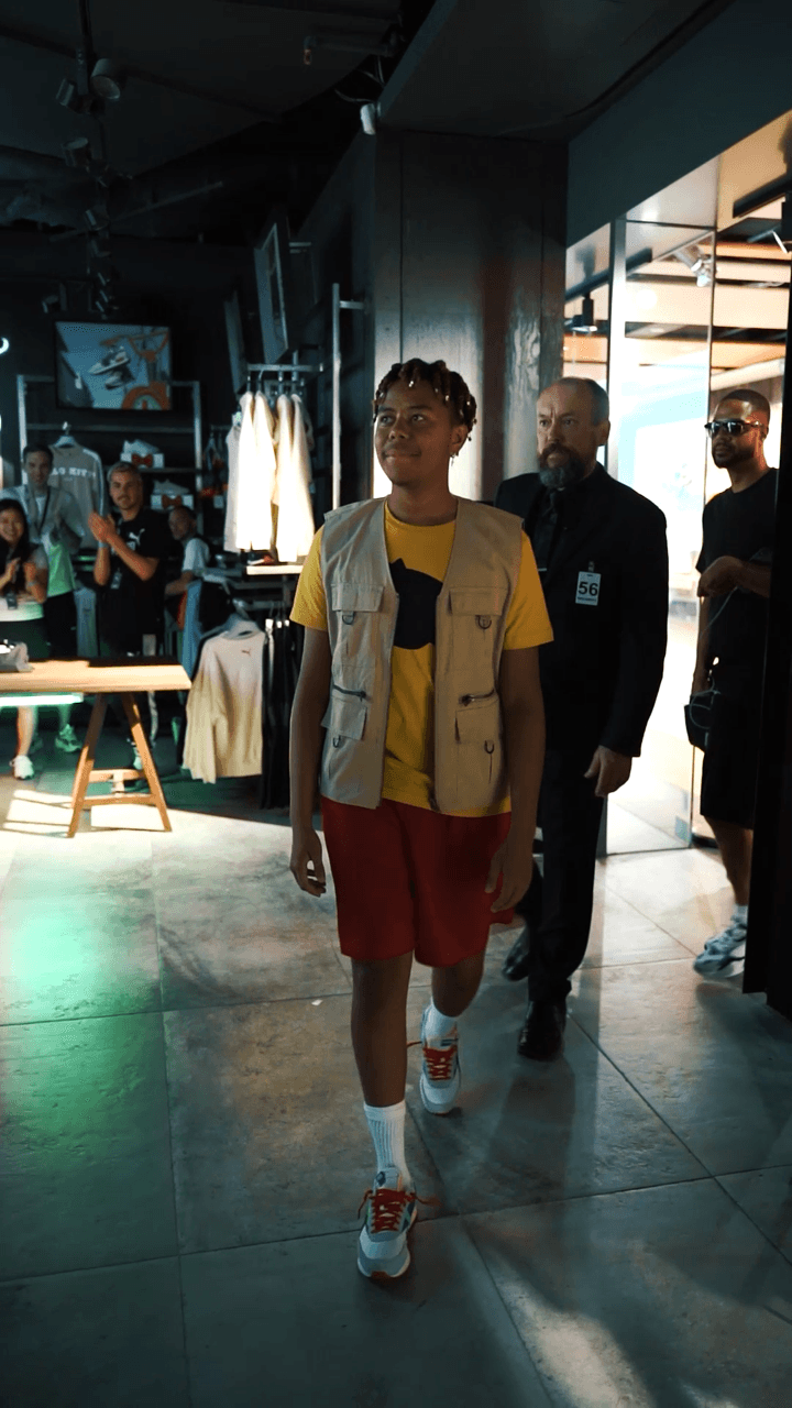 Cordae walking with a bodyguard behind him