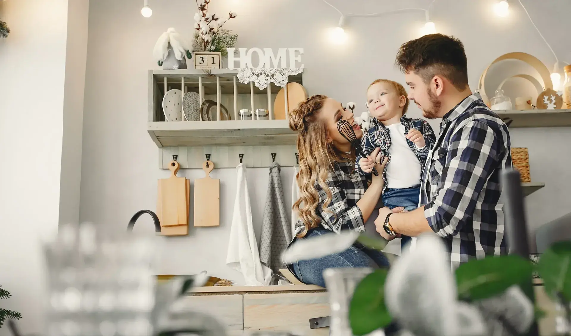 Young couple smiling while holding their toddler inside a warm, modern home – first‑time homebuyers using an FHA loan in Baton Rouge, Louisiana.