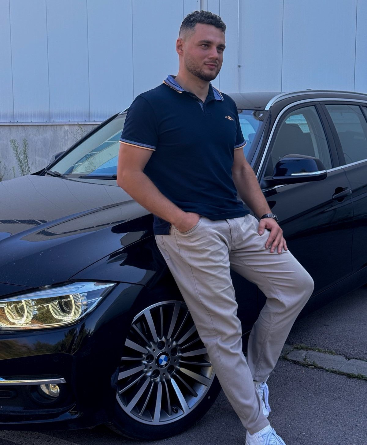 a man sitting next to a car