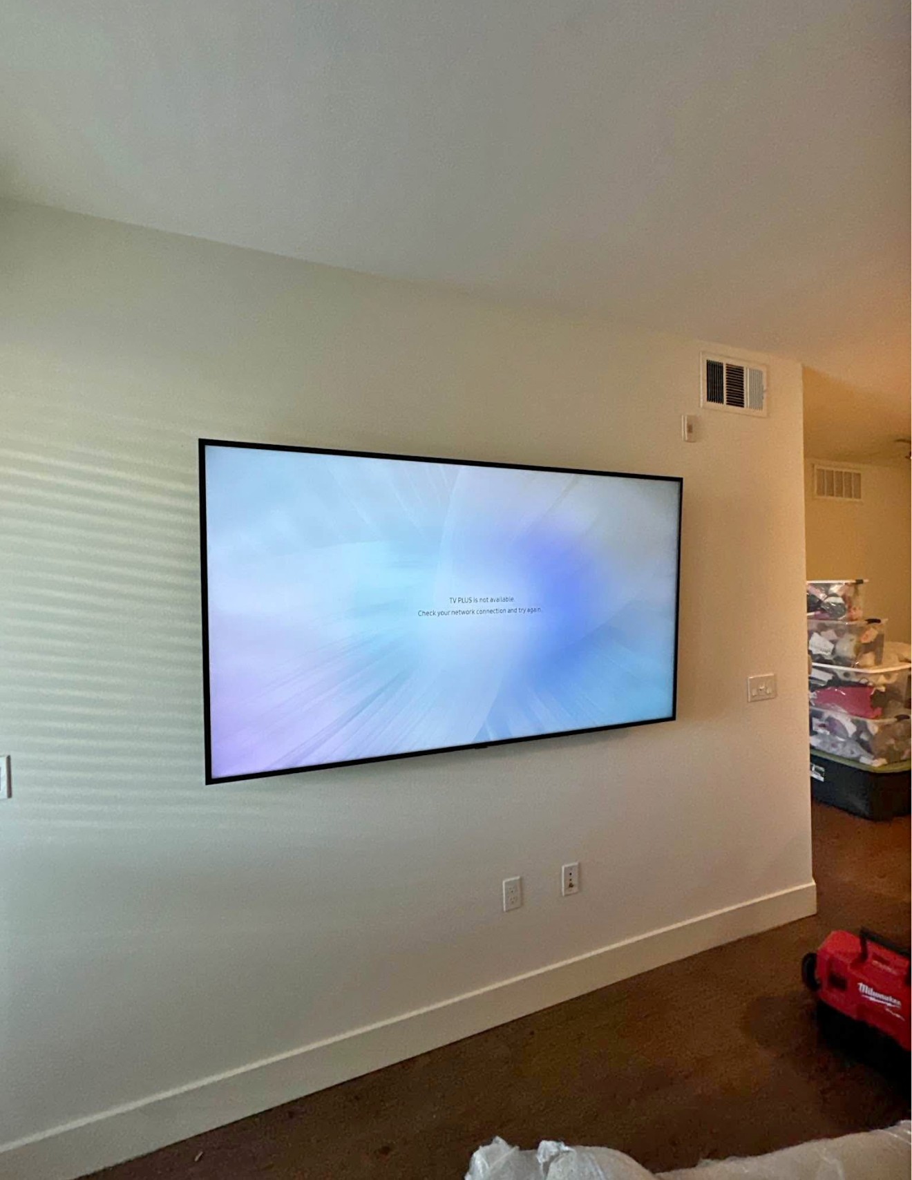 65-inch TV mounted using a standard wall mount setup in a residential home in Atlanta, with clean wiring and a modern look.