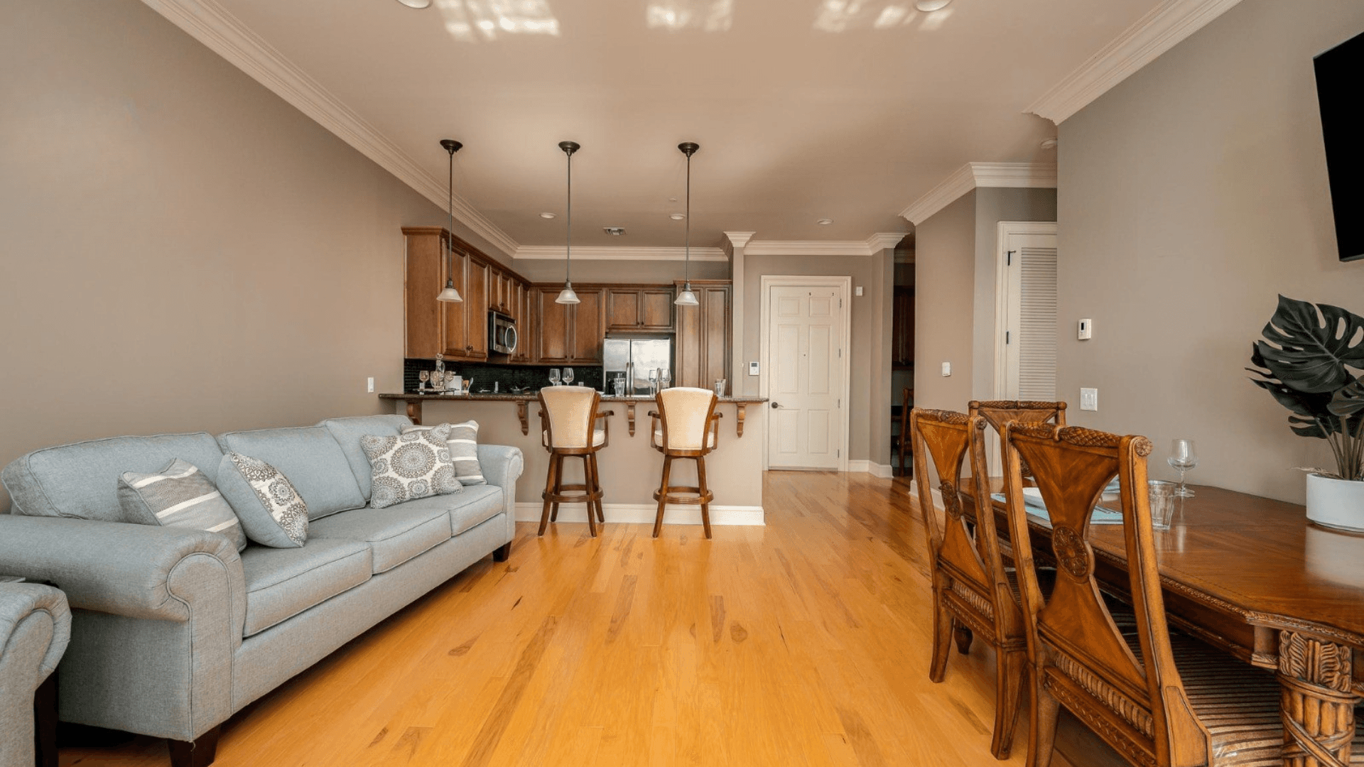 Spacious open-concept living area at The Gateway Village with hardwood floors, connecting the kitchen, dining space, and lounge for easy, comfortable living.