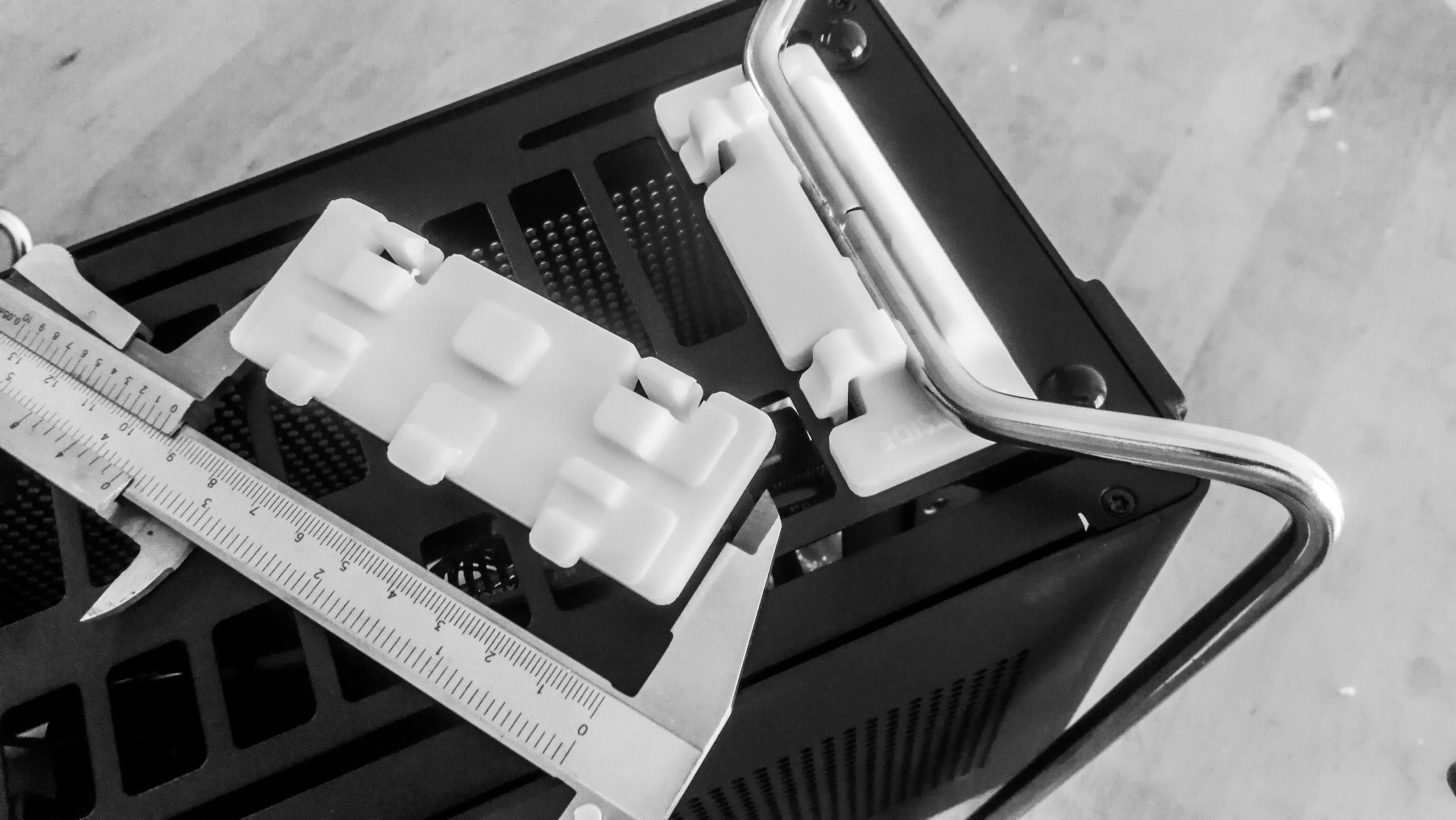 Calipers measuring a 3D printed computer part.