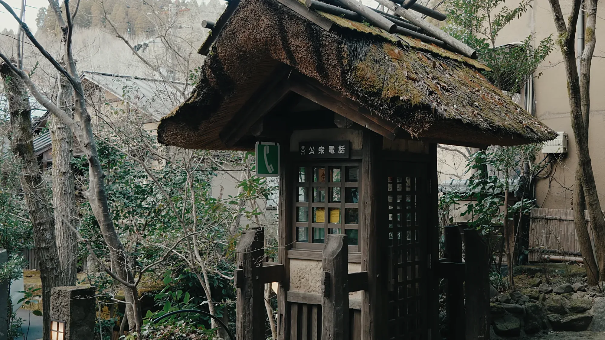 A roofed timber noticeboard at Kurokawa Onsen carrying a posted notice