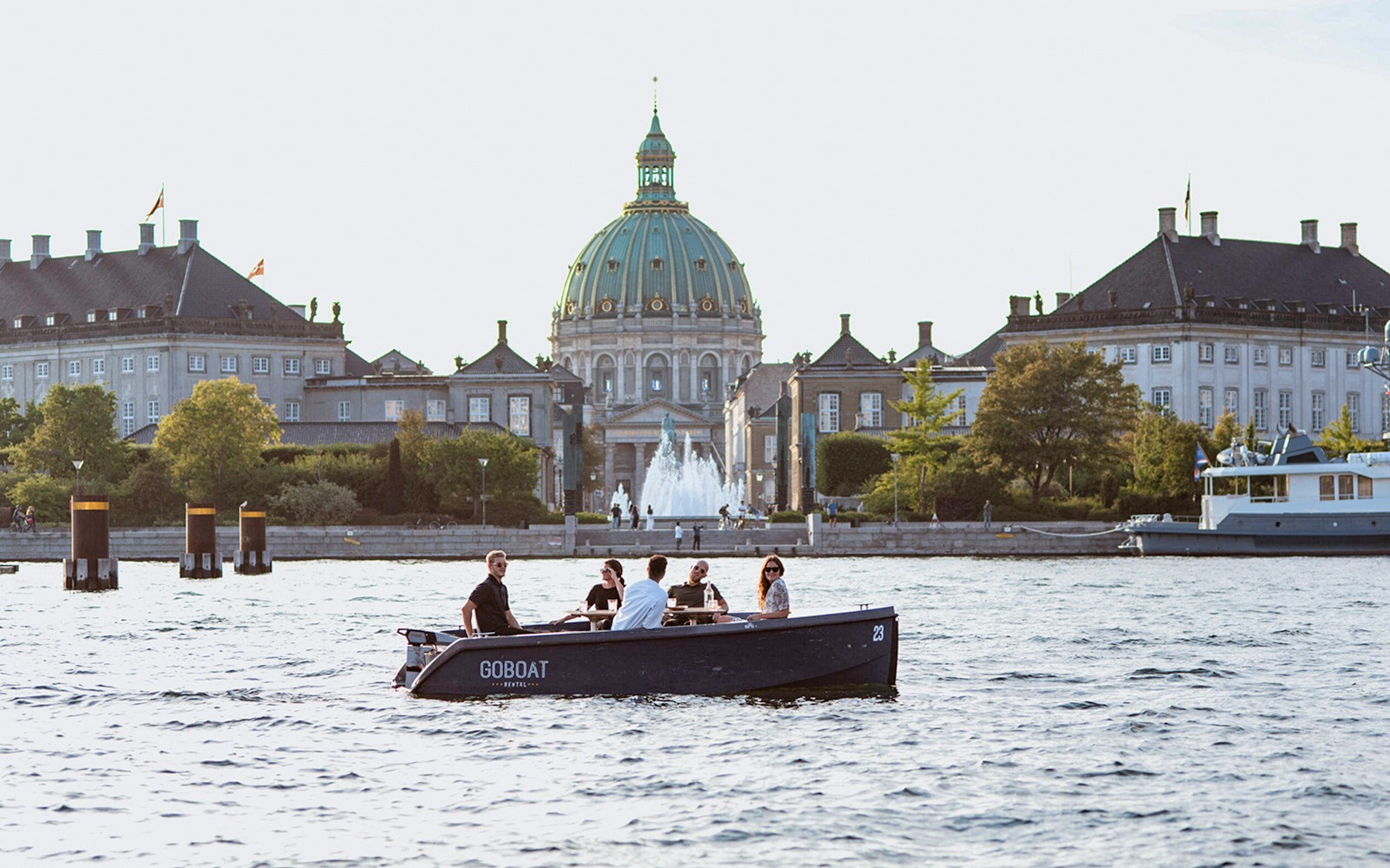 Vendégek egy koppenhágai hajókiránduláson, a háttérben a Fredrick's templomával.