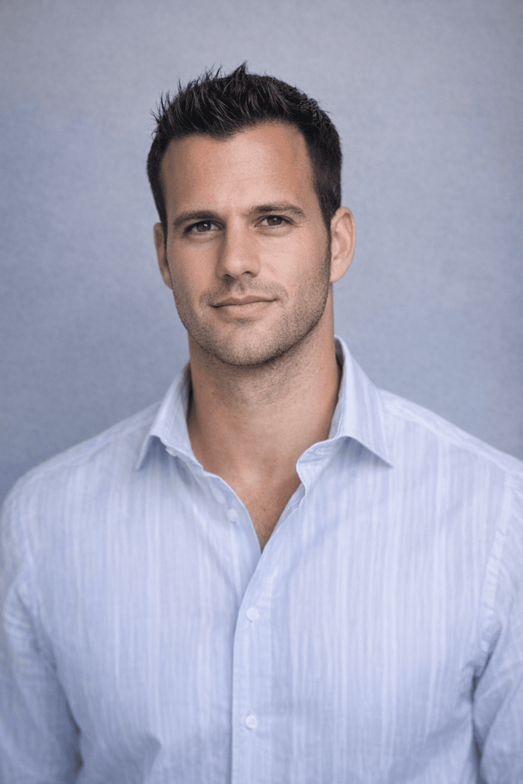 Black and white portrait of a smiling person with curly hair