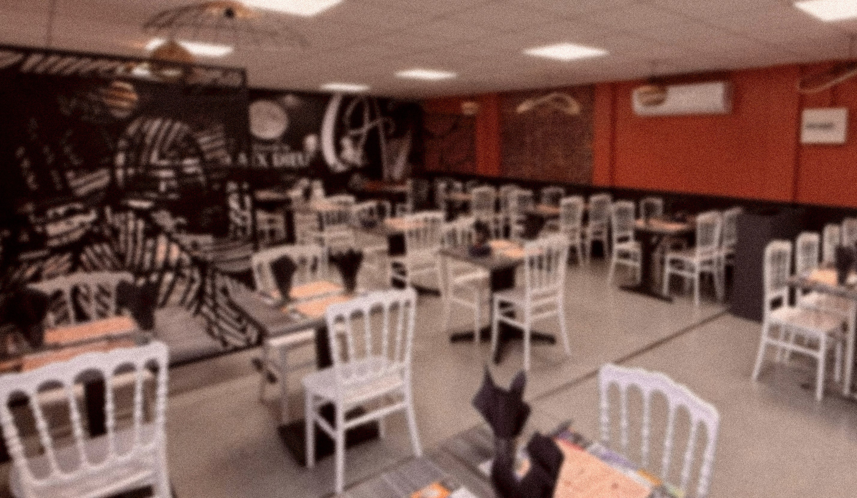 Modern indoor space with large glass doors, lush greenery, and a cozy seating area visible beyond.