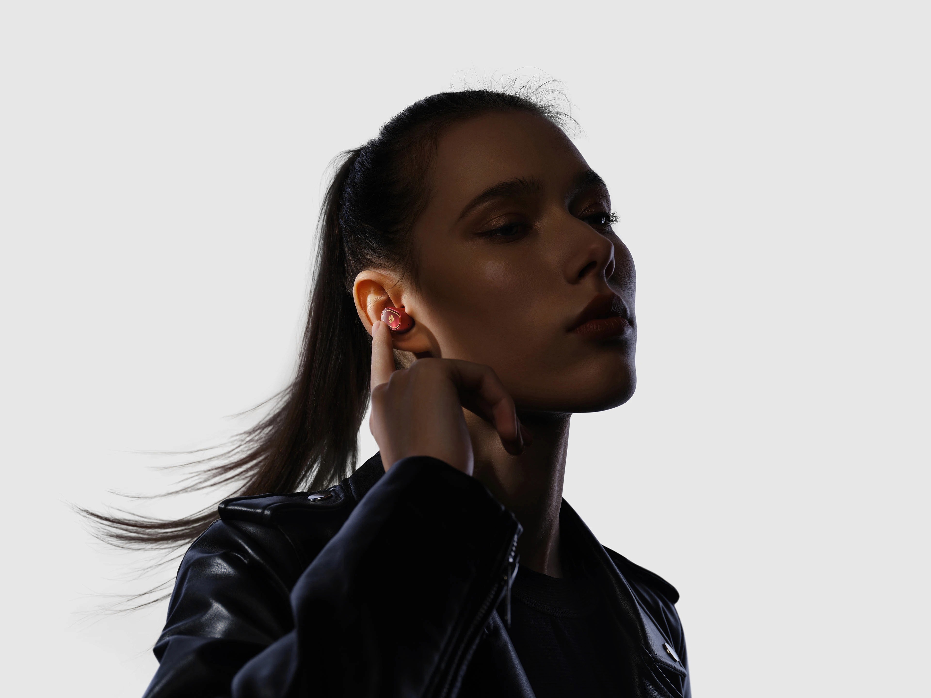 woman wearing earbuds and hand on her ear
