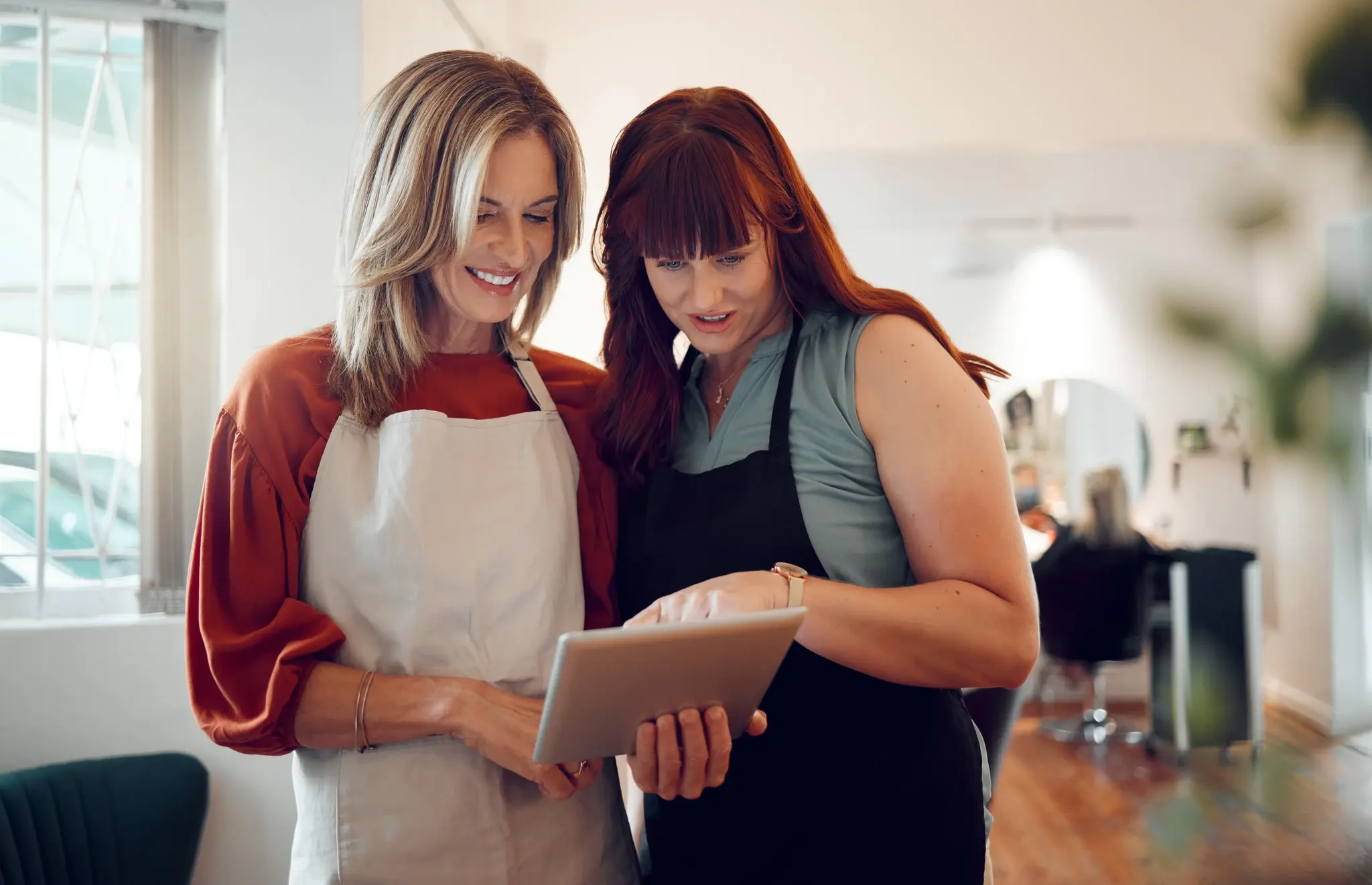 Deux coiffeuses partageant les avis Google positifs du salon
