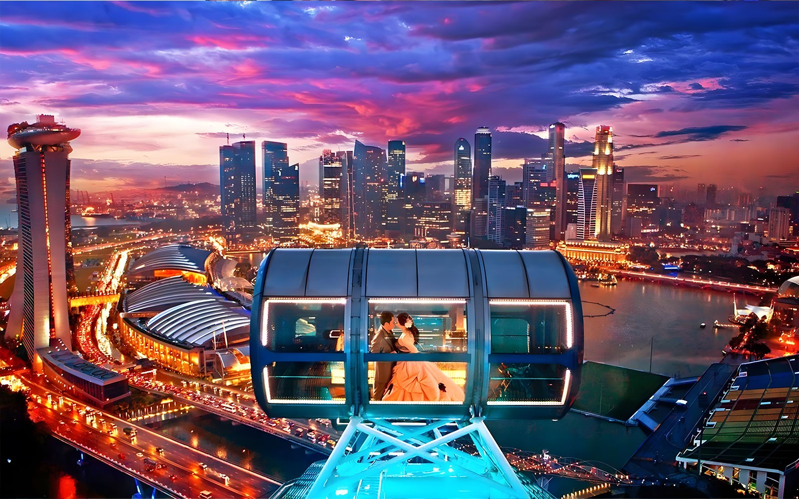 Couple in a cabin on the Singapore Flyer with city skyline view.