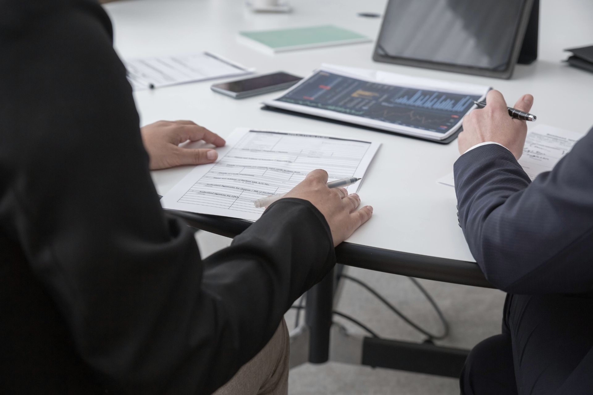 Business partners reviewing data charts and signing an AI automation service agreement