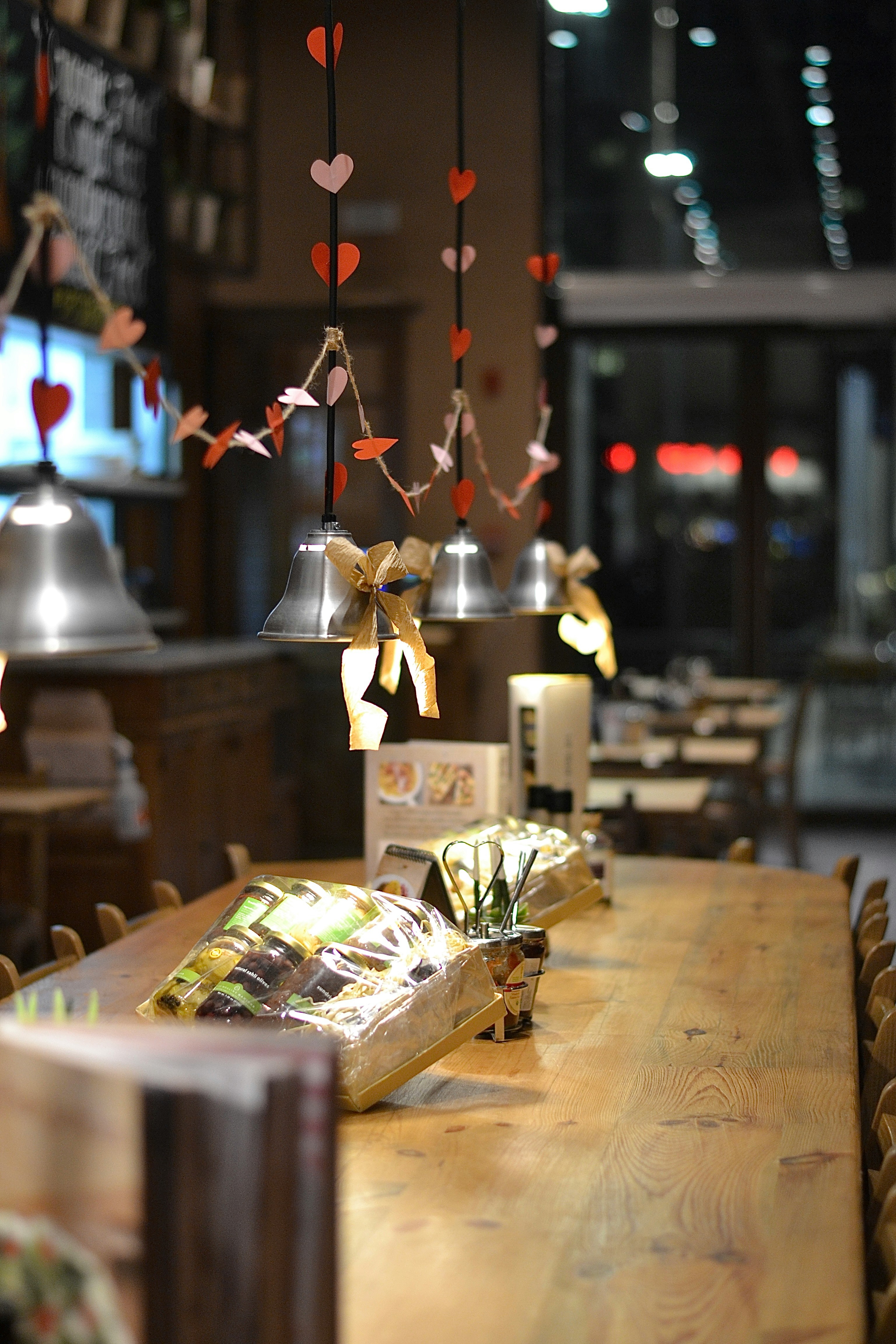 Decorated cafe tables with heart garland and bells.