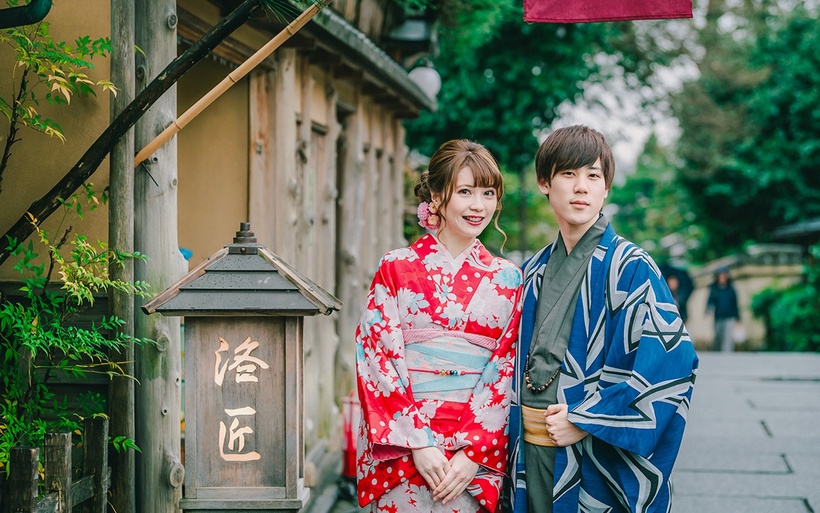 Pareja en kimonos tradicionales posando en una calle de Japón.