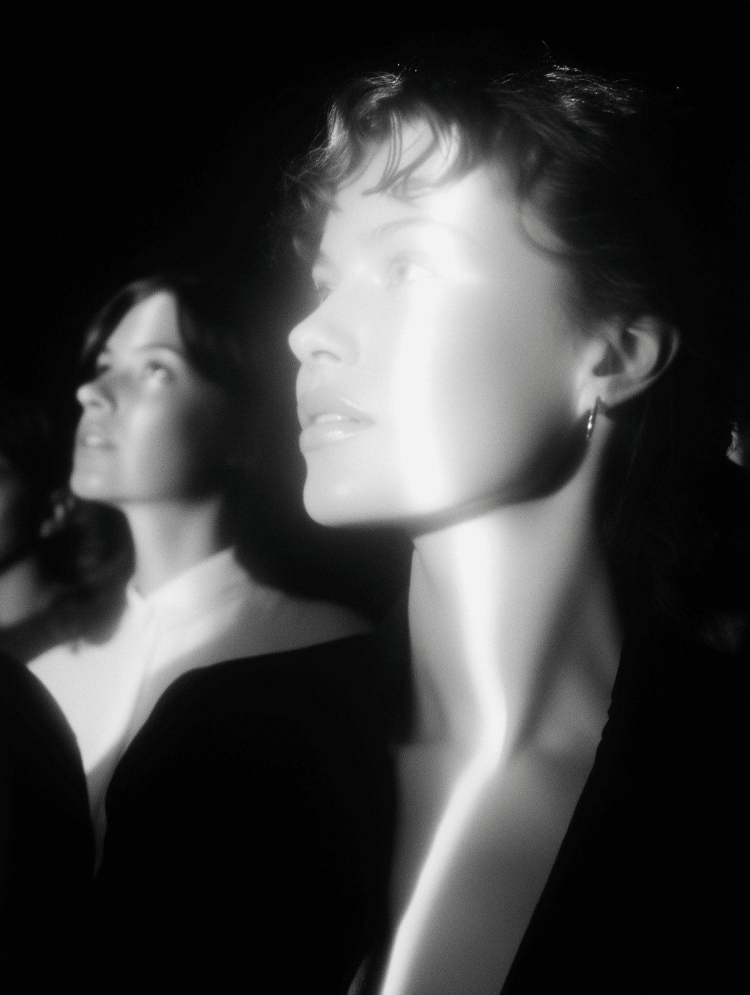 A women with mirror reflection, looking upward with dramatic highlights