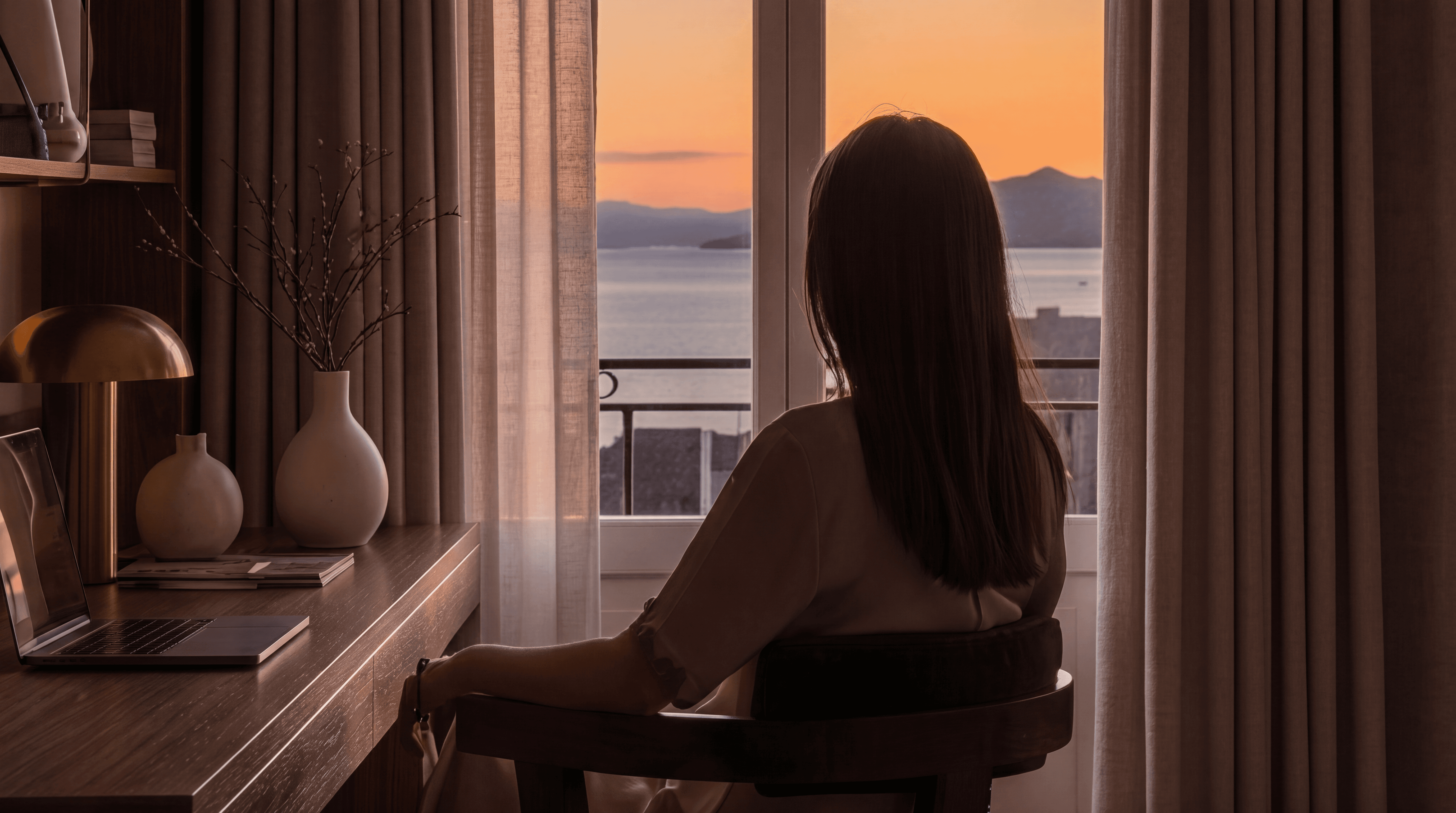 Silhouette contemplant le coucher de soleil sur le lac Léman depuis une chambre d'hôtel design