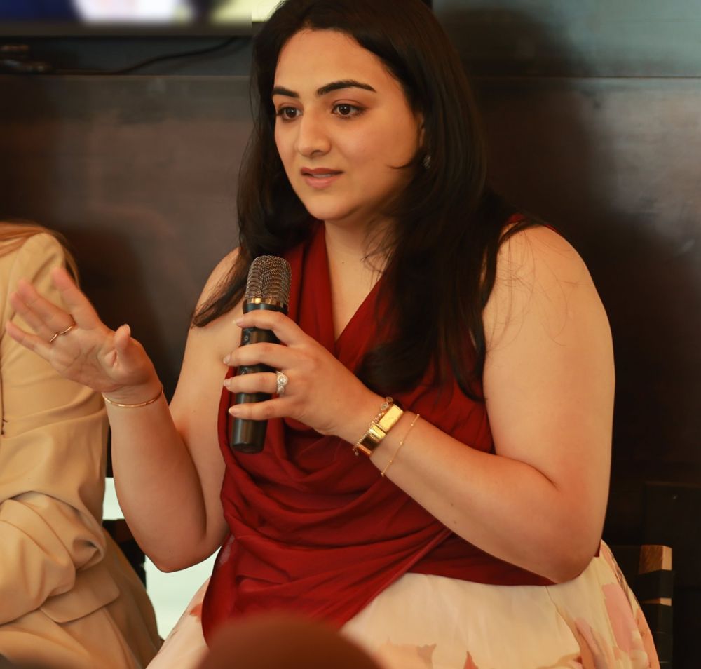 Karishma speaking on a panel with a microphone