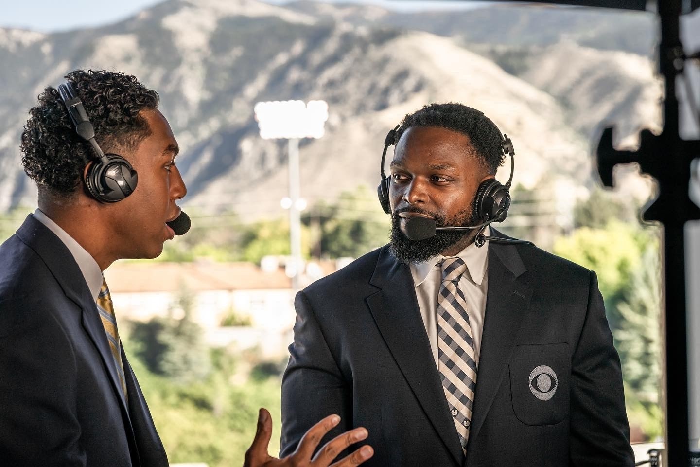 Robert Turbin and a sports commentator in suits speaking with headsets on.
